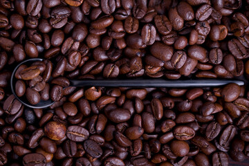 Obraz premium Coffee beans on a black spoon