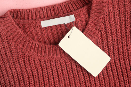 Mockup of a label and an inner label on the neck of a pretty red wool sweater. Blank space to place a logo, text or image