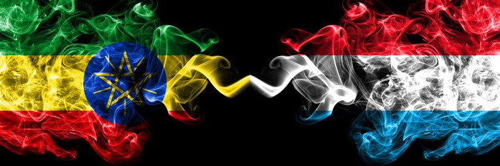 Ethiopia, Ethiopian vs Luxembourg smoky mystic flags placed side by side. Thick colored silky abstract smoke flags.