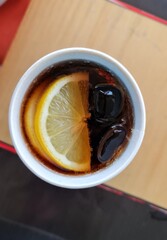 Drink with ice and lemon in cup in restaurant