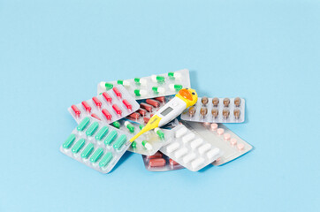 medical tablets and preporata with a thermometer lie on a blue background