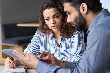 Male indian teacher, manager or mentor discussing papers with latin student, client at business meeting, helping employee with contract, teaching intern showing documents, doing paperwork together. - obrazy, fototapety, plakaty