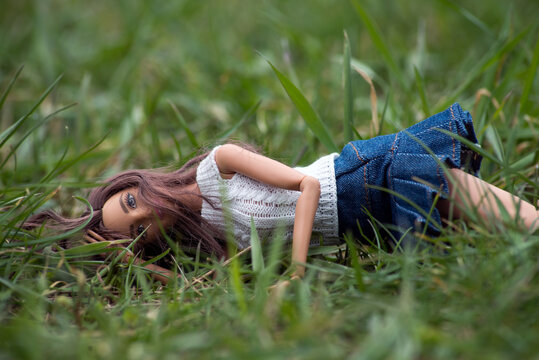 Mulhouse - France - 21 March 2021 - Portrait of brunette Barbie doll lying in the grass in a public garden