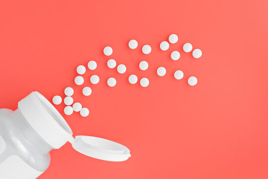 topview of methyl folate tablets flying from the jar. dietary concept. dietary supplement close-up