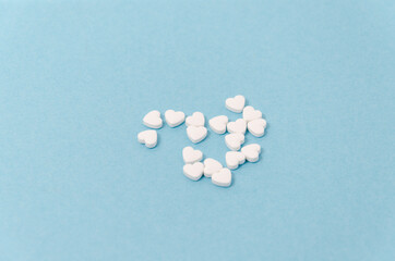 heart shaped medical pills on blue background
