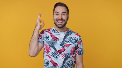 Surprised funny bearded young man 20s years old wearing basic casual summer t-shirt isolated on bright yellow background in studio. People emotions lifestyle concept. Say wow showing ok okay gesture