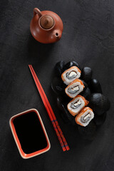 Japanese sushi served on  black stones. Top view, close up on dark   background.