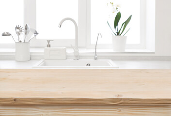 Blur kitchen sink counter in front of wooden table top
