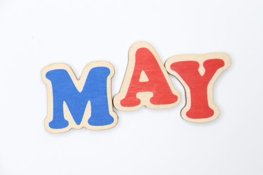 Text "may" from wooden color letters on a white background.