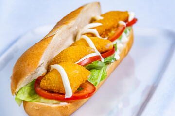 Baguette stuffed with cheese nuggets and vegetables. Food styling for street food. Closeup.