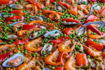Spanish seafood paella in fry pan with mussels, shrimps and vegetables