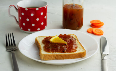 Sandwich with homemade carrot orange jam on a white plate