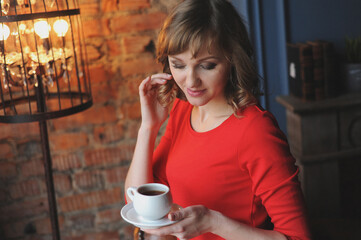 beautiful girl in a red dress holding a cup of coffee