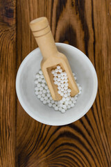 Homeopathy alternative medicine eco concept - classical homeopathy pills. Homeopathic globules on wooden background. 