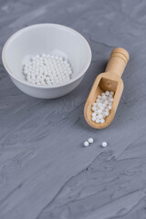 Homeopathy alternative medicine eco concept - classical homeopathy pills. Homeopathic globules on gray background. 