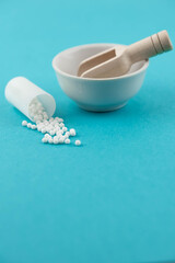 Homeopathy alternative medicine eco concept - classical homeopathy pills. Homeopathic globules on blue background. 