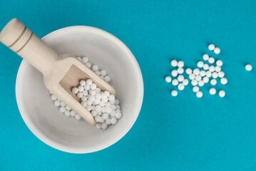 Homeopathy alternative medicine eco concept - classical homeopathy pills. Homeopathic globules on blue background. 