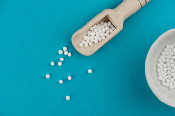 Homeopathy alternative medicine eco concept - classical homeopathy pills. Homeopathic globules on blue background. 