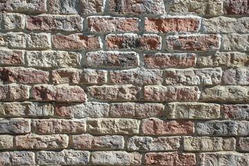 View of old shabby wall made from multicolored bricks. Abstract textured background. Copy space for your text and decorations.