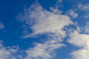 Blue sky with white grainy clouds.