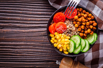 bowl of healthy quinoa with vegetables on a dark rustic background