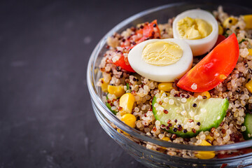 bowl of healthy quinoa with vegetables on a dark rustic background