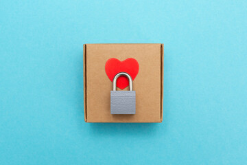 Heart lock. Self-gathering cardboard box. Delivery, moving, gift wrapping on a colored background.