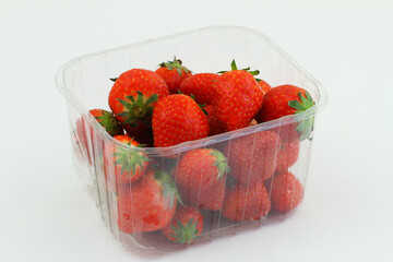 Fresh sweet strawberries in transparent plastic box on white background
