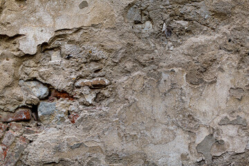 Old dark gloomy dirty crumbling brick wall of ancient facade. Uneven pitted rot surface of fissured brickwork. Ruined ragged gaping hole retro fortress. Decayed daub brickwall background for 3D design
