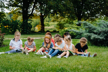 A teacher teaches a class of children in an outdoor Park. Back to school, learning during the pandemic