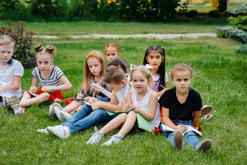 Fototapeta premium A teacher teaches a class of children in an outdoor Park. Back to school, learning during the pandemic