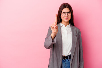 Young caucasian business woman isolated on pink background showing number one with finger.