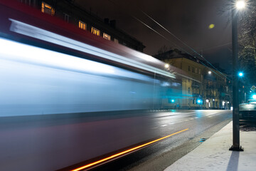 Electric bus trolleybus passing long exposure night in Vilnius, Rain.