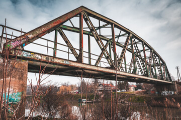 An old rusty railway bridge with a dramatic sky
