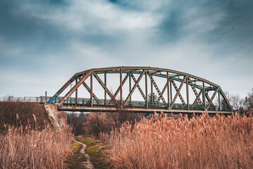 Fototapeta na wymiar An old rusty railway bridge with a dramatic sky