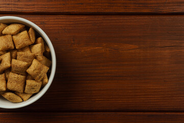 Chocolate-filled breakfast pads in a white bowl on a dark table. Top view
