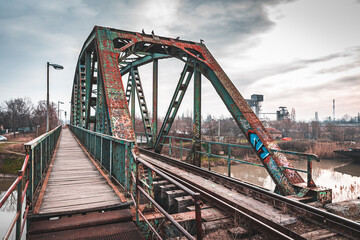 Fototapeta na wymiar An old rusty railway bridge with a dramatic sky