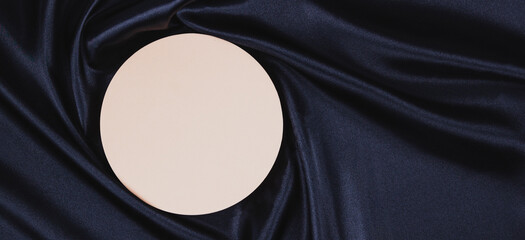 Pastel circle platform podium on black color background with drapery and wavy folds of silk satin...