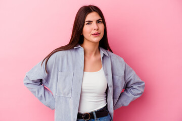Young caucasian woman isolated on pink background blows cheeks, has tired expression. Facial expression concept.