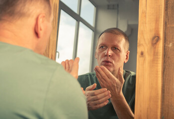 Happy mature man looking at his mirror reflection and sending kiss to himself. Healthy self-image...