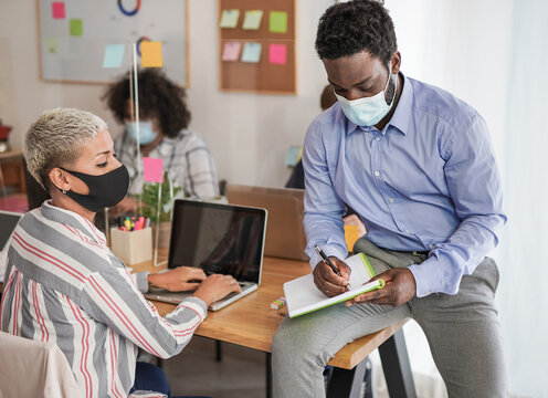 Young multiracial people wearing protective face mask at work in office - Prevention for coronavirus