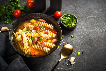 Vegetable soup with pasta and sausages.