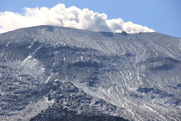 長野県と群馬県にまたがる、うっすらと雪が残っている浅間山　(稜線に見える突起物は、「千トン岩」と呼ばれる巨大な噴石)