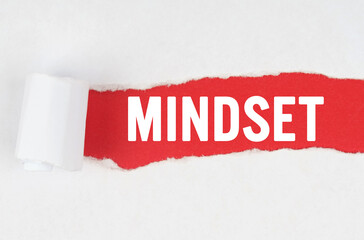 Behind torn white paper on a red background, the text - MINDSET