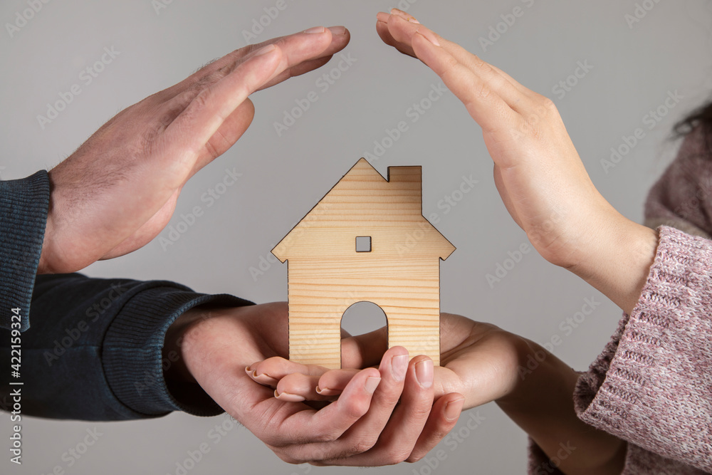 Wall mural woman and man holding house model