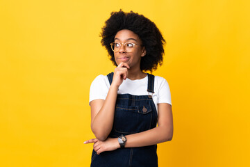 Fototapeta na wymiar Young African American woman isolated on yellow background having doubts and thinking