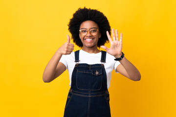 Fototapeta premium Young African American woman isolated on yellow background counting six with fingers