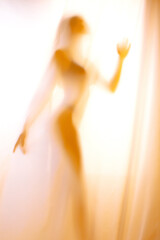 Silhouette of girl behind a curtain. Blurry hand and body figure abstract.