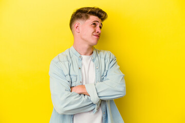 Young caucasian man isolated on yellow background dreaming of achieving goals and purposes