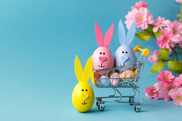 Shopping cart, Eeaster eggs bunny on blue background, copy space. sale concept